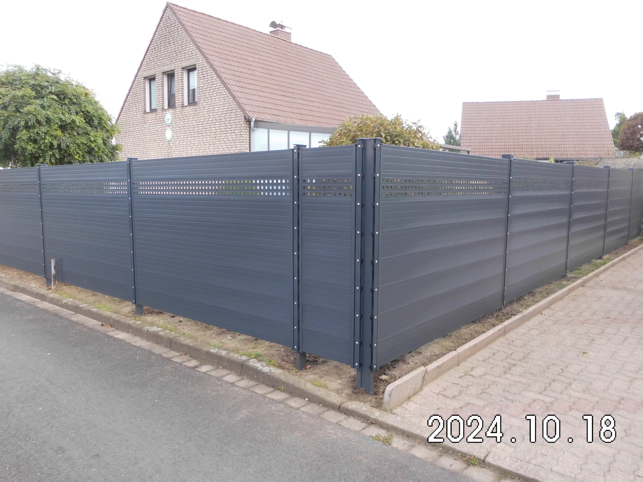 Pflegeleichter Sichtschutzzaun in Hannover aus Aluminium in Anthrazit mit dekorativem Lochblech-Element für stilvolle Abgrenzung.