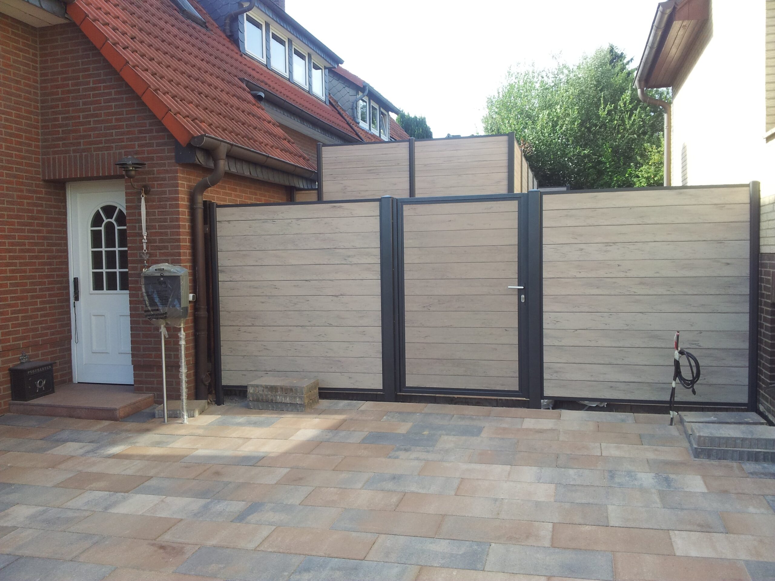 Moderne WPC-Sichtschutztuer mit Aluminiumrahmen von Klingenberg Zaeune aus Garbsen – ideal für Einfahrten und blickgeschuetzte Bereiche