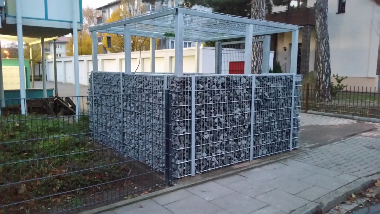 Einfriedung eines Containerstellplatzes mit robusten Gabionen und modernem Zaunsystem als Sicht- und Windschutz