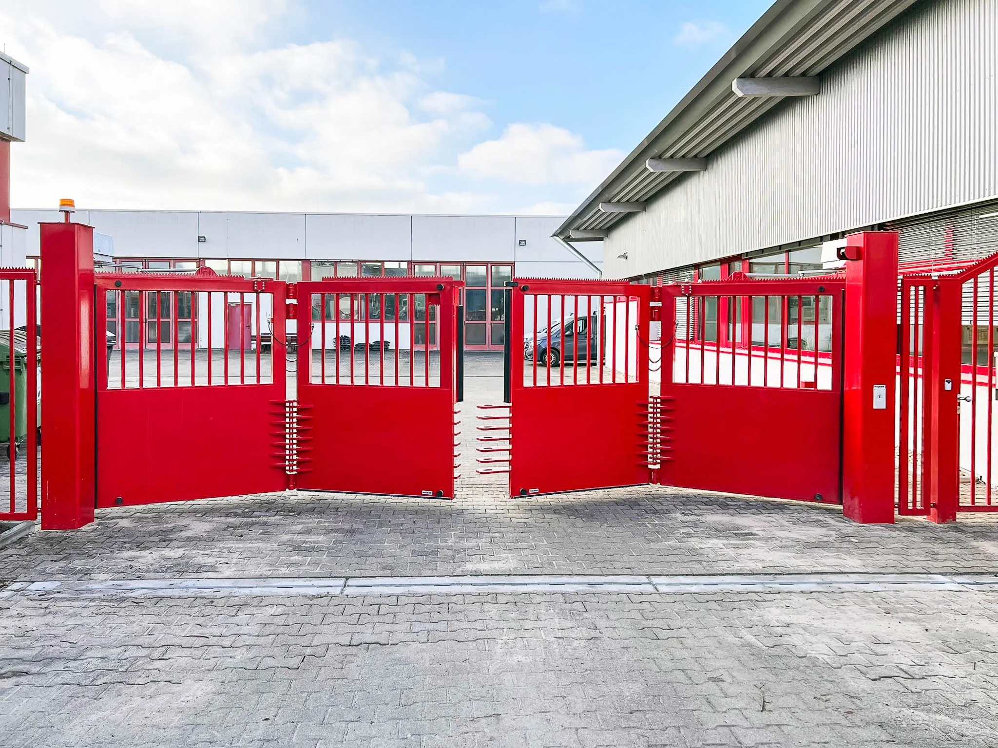 Rotes industrielles Drehtor mit Teilblechfüllung und Übersteigschutz – Sicherheitslösung für Betriebsgelände von ZABAG.