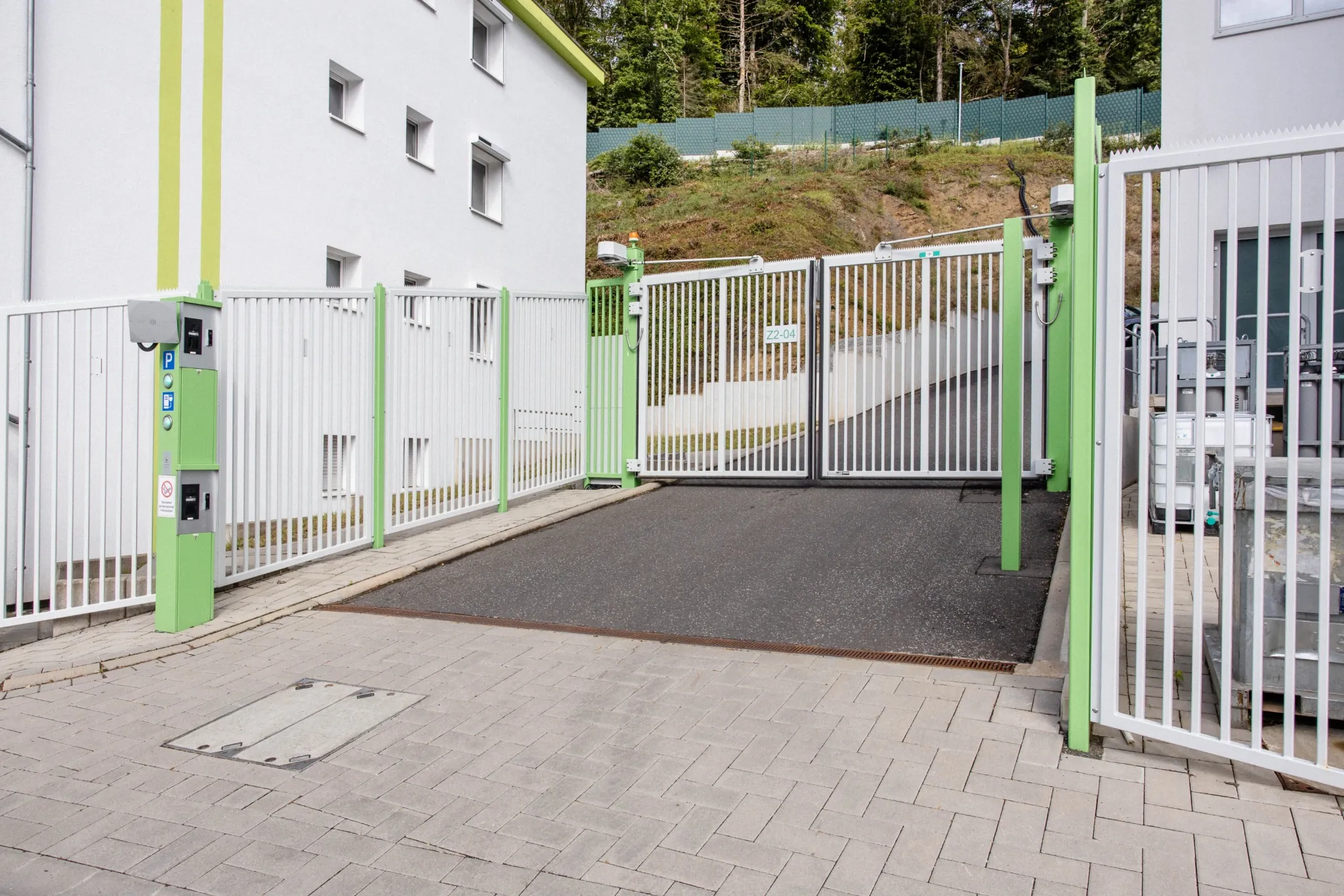 Industrielles Drehtor mit Stabfüllung in Grün und Weiß – sichere Zufahrtskontrolle für Wohn- und Gewerbeanlagen von ZABAG.