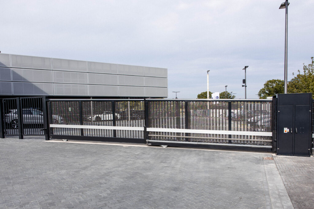 Industrieschiebetor mit Gitterfüllung und integrierter Zugangstechnik – Sicherheitsanlage von ZABAG