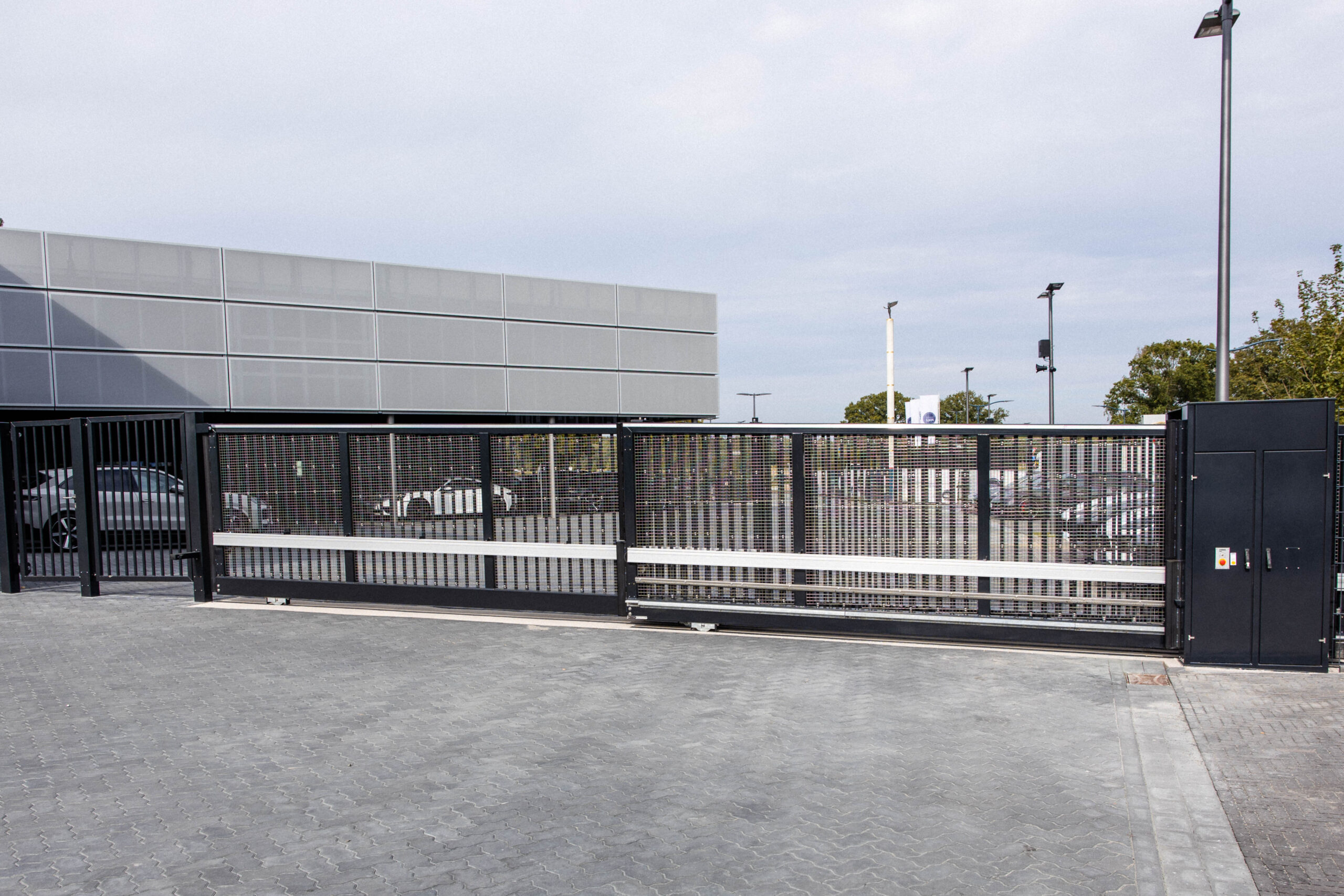 Industrieschiebetor mit Gitterfüllung und integrierter Zugangstechnik – Sicherheitsanlage von ZABAG