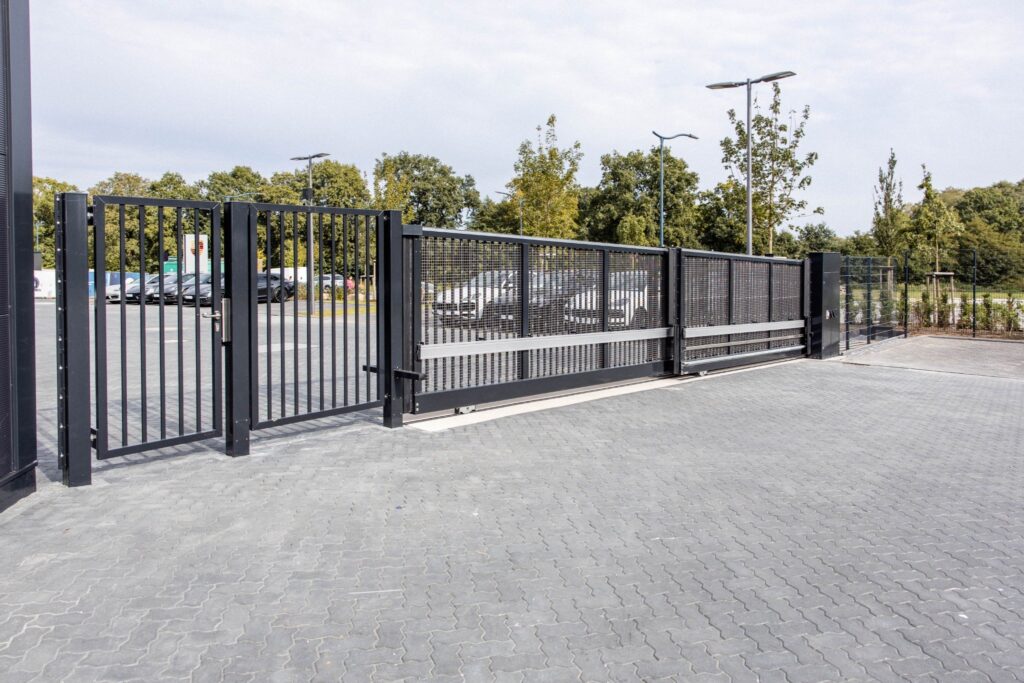 Industrieschiebetor mit Gitterfüllung und integrierter Schlupftür – Sicherheitstor von ZABAG